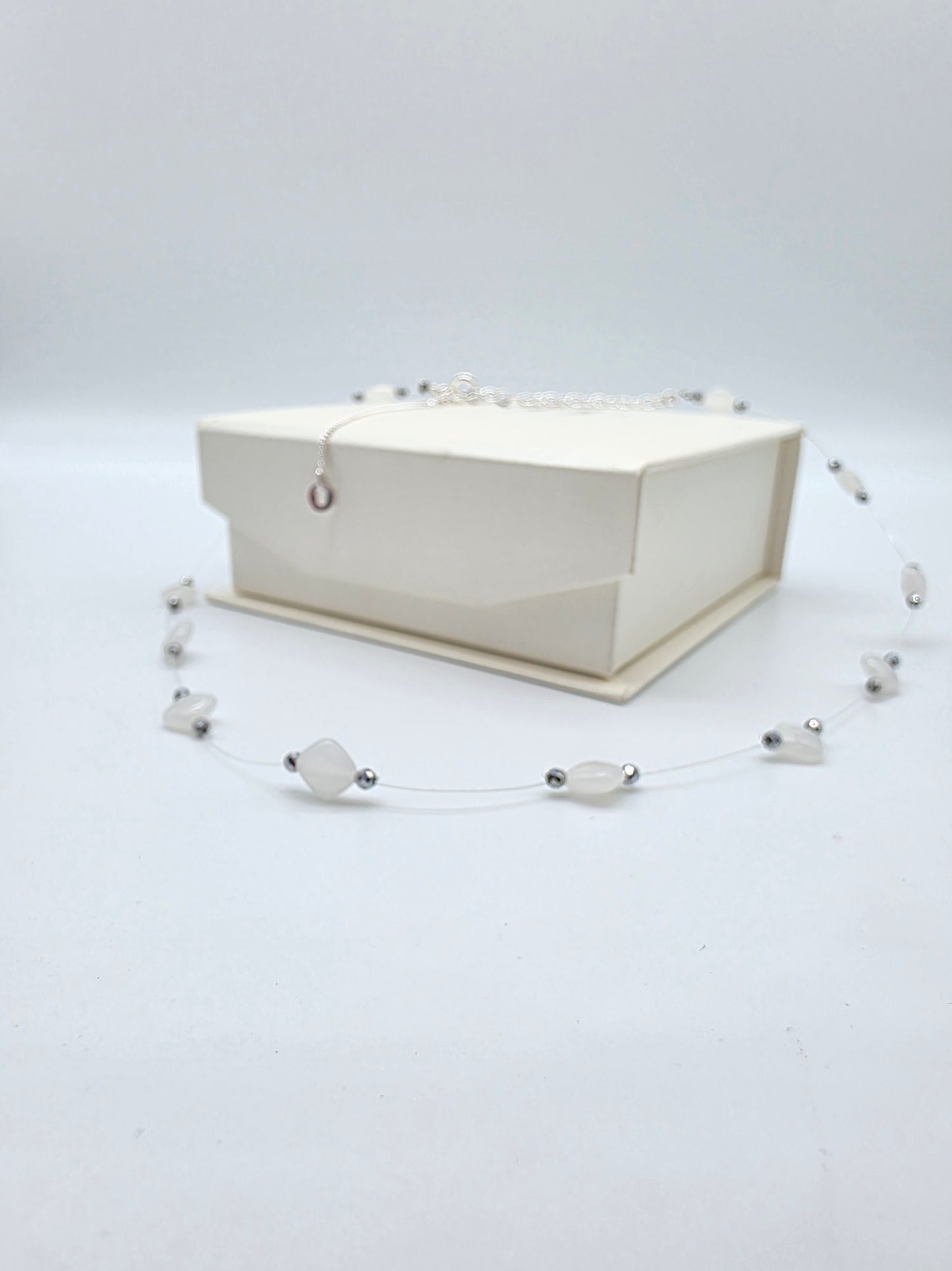 Floating halsband med vita naturstenar och silverfärgade kristaller